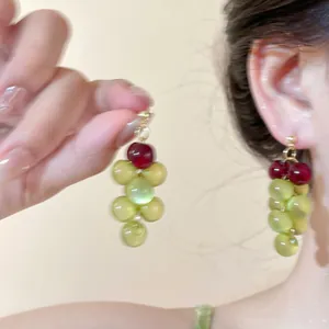 Vista detallada de pendientes de cuentas en forma de uva con resina verde y roja