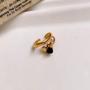 Detail view of an elegant gold stainless steel open ring featuring a black heart zircon