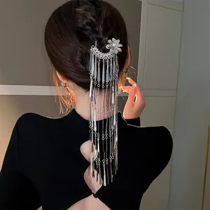 Detailed view of elegant silver flower hair fork with long metal tassels on hair bun