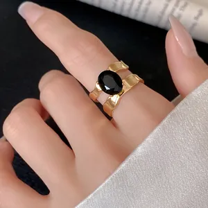 Close-up of a gold-plated stainless steel ring with a large oval black gemstone