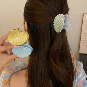 Iridescent scallop shell hair claw clips in pearl white, yellow and blue finishes.
