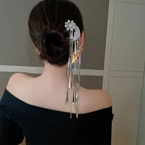 Detailed view of an elegant flower tassel hair fork worn on a classic bun hairstyle