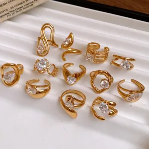 Macro view of gold-plated stainless steel rings with zircon stones on a white tray
