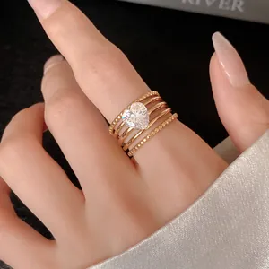 Close-up view of gold multi-layer ring with a sparkling heart-shaped zircon stone.