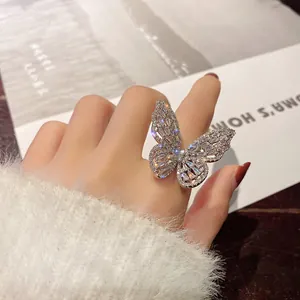 Macro view of exquisite butterfly ring with sparkling cubic zirconia on index finger.