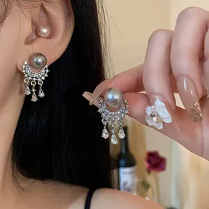 Primo piano di orecchini di perle a nappa di lusso francese con strass e ago d'argento