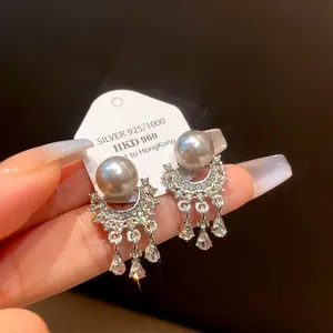 Dettaglio ravvicinato di orecchini vintage in argento S925 con perle e nappe di strass