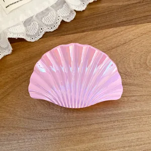 Close-up of pink iridescent shell-shaped hair claw clip with pleated texture