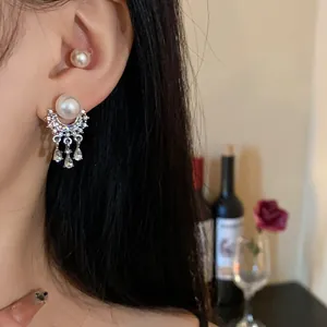 Dettaglio di eleganti orecchini francesi vintage in argento con perle e nappe fini.