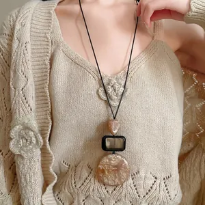 Vintage resin pendant long sweater necklace for women with amber teardrop and square charms.
