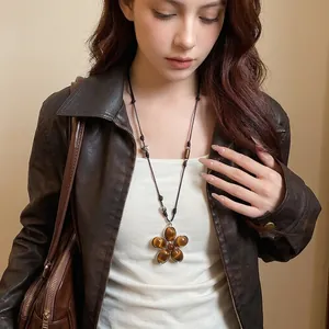 Vintage leather cord necklace featuring a tiger eye flower pendant worn by a model