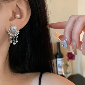 Dettaglio di orecchini di lusso francesi con perle, strass e nappe sulla modella