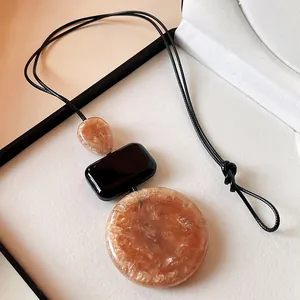 Retro long resin necklace with amber-toned geometric pendants on black cord