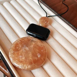 Close-up of vintage geometric resin necklace pendants with amber and black marbled texture