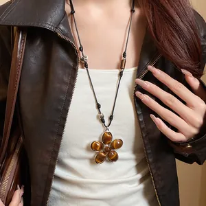 Vintage flower pendant necklace with tiger eye stones worn with a leather jacket