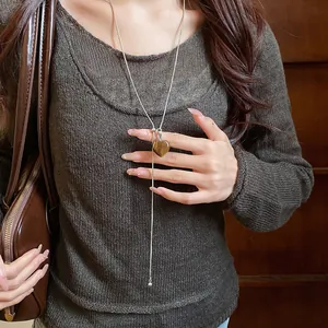 Close-up of vintage heart-shaped tiger's eye pendant necklace on a model