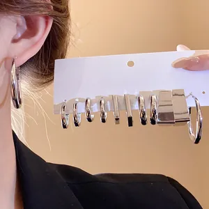 Detailed view of silver-tone geometric hoop earring set displayed on a white card