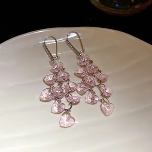 Gros plan de boucles d'oreilles en verre de cristal rose en forme de cœur avec zircons