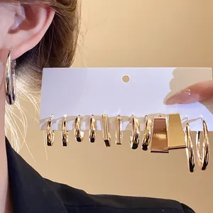 Close-up of a gold-toned geometric earring set featuring hoop and rectangular designs