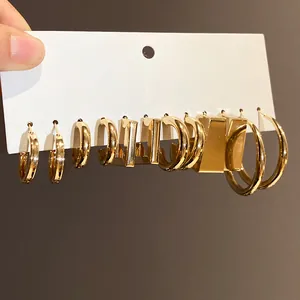 Detailed view of minimalist gold geometric hoop earring set on white display card