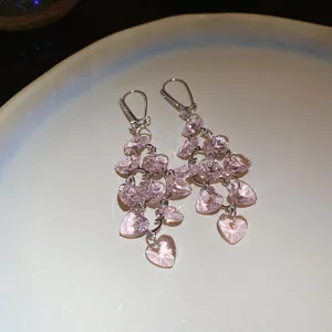 Détail macro de boucles d'oreilles en cristal de verre rose en forme de cœur avec zircons