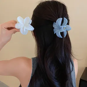 Primo piano di eleganti fermagli per capelli a fiore nei colori blu e bianco su capelli