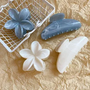 Dettaglio mollette per capelli in acrilico marmorizzato blu e bianco a forma di fiori