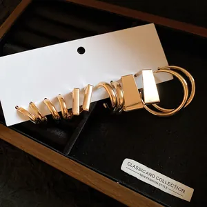 Detailed close-up of a six-piece geometric gold earring set in a jewelry tray