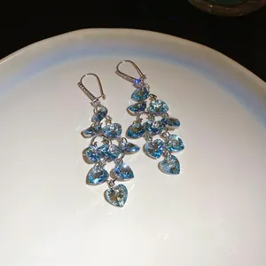 Vue détaillée de boucles d'oreilles cœur à pampilles bleues et crochets zircon
