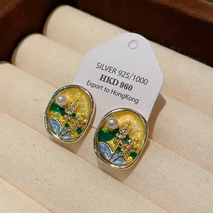 Close-up of elegant oil-drop flower earrings with pearl and silver needle details