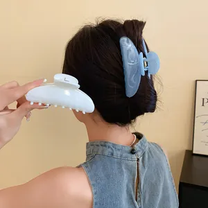 Vista dettagliata di mollette per capelli in acrilico con motivo marmorizzato blu e bianco