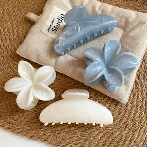 Primo piano dettagliato di eleganti mollette per capelli in acrilico marmorizzato blu e crema