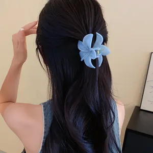 Vista posteriore di una pinza per capelli a fiore in acrilico azzurro su capelli ondulati