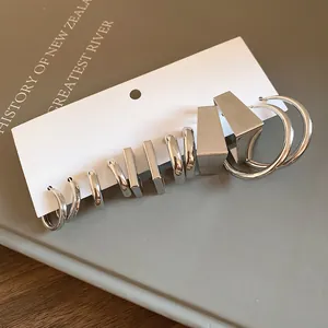 Detailed view of minimalist silver-toned geometric hoop and stud earring set