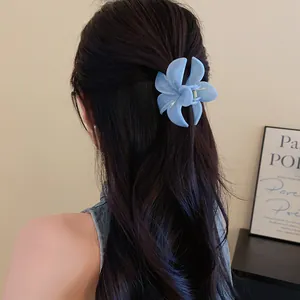 Vista dettagliata di una molletta per capelli a fiore in acrilico blu su capelli lunghi