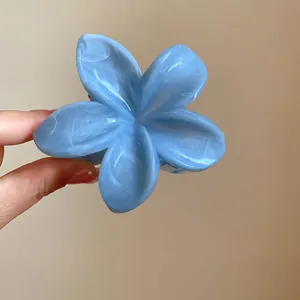 Primo piano di una molletta per capelli a fiore in acrilico blu marmorizzato elegante
