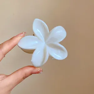 Vista dettagliata di una pinza per capelli a fiore bianco marmorizzato