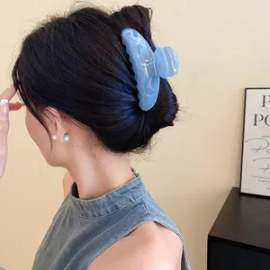Vista dettagliata di una pinza per capelli in acrilico blu marmorizzato sui capelli