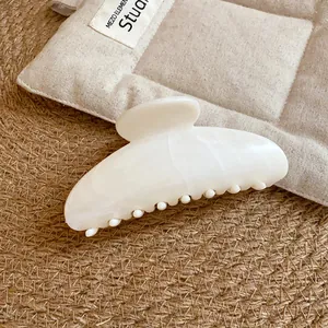 Primo piano di un'elegante pinza per capelli in acetato marmorizzato avorio