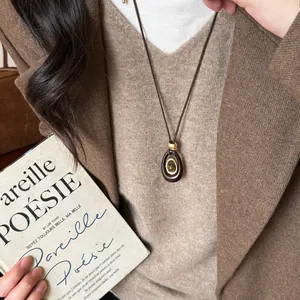 Dettaglio dell'elegante collana ovale in resina con pietra naturale occhio di tigre