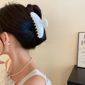 Vista dettagliata di una pinza per capelli in acrilico bianco marmorizzato su acconciatura