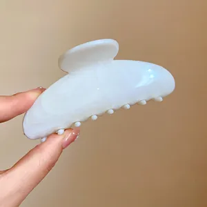 Elegante pinza per capelli in acrilico marmorizzato bianco per acconciature femminili, dettaglio.