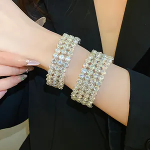 Close-up of elegant multi-row rhinestone bangles worn on a wrist for evening wear.