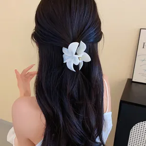 Dettaglio posteriore di elegante molletta per capelli a fiore in acrilico bianco