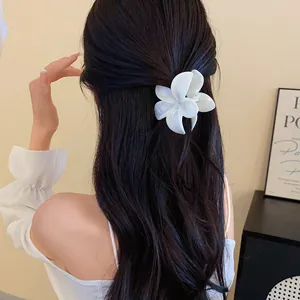 Vista dettagliata di un fermaglio per capelli a fiore in acrilico bianco in un'acconciatura