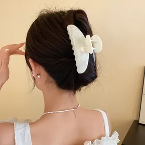 Dettaglio di una pinza per capelli in acrilico bianco marmorizzato su un'acconciatura