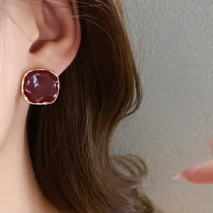 Detailed view of an elegant red enamel square stud earring with a golden border finish