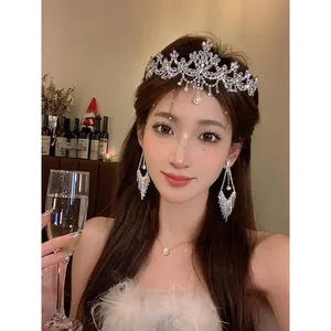 Detail showing an elegant zircon flower tiara and matching crystal earrings on a female model