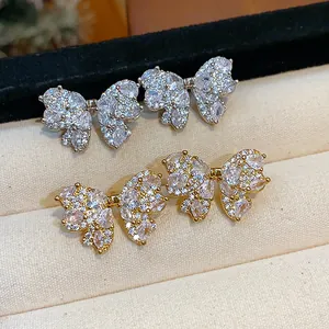 Close-up of sparkling zircon bow-knot stud earrings in gold and silver finishes