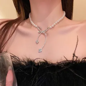 Elegant French style baroque pearl necklace featuring a sparkling diamond bow pendant.